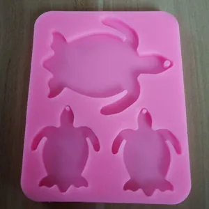 Detail view of pink silicone mold featuring three turtle-shaped cavities for DIY crafts