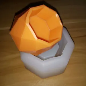 Close-up view of geometric succulent pot silicone mold with orange finished product