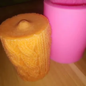 Texture détaillée d'un motif tricoté sur une bougie d'aromathérapie cylindrique.