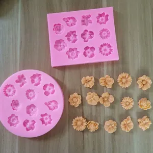 Vue détaillée de moules à fleurs en silicone DIY et de formes de fondant sur du bois.