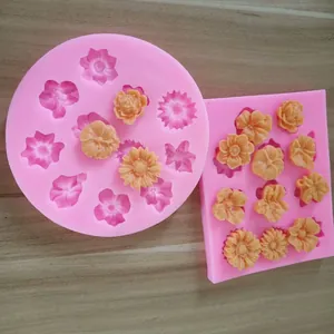 Détail de moules en silicone rose ronds et rectangulaires pour formes de fleurs en fondant