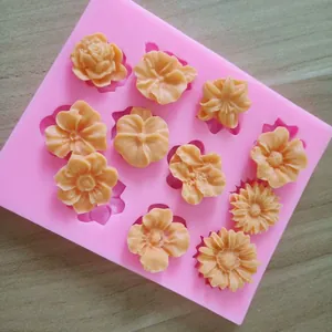 Vue détaillée macro du moule en silicone rose avec divers fondants en forme de 11 fleurs