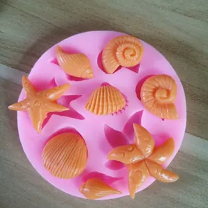 Macro detail of a pink silicone baking mold with various seashell and starfish shapes
