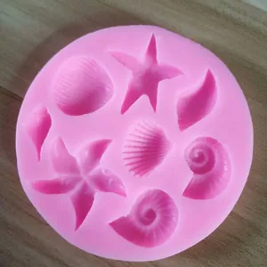 Close-up view of pink silicone baking mold featuring intricate starfish and seashell cavities