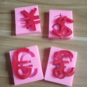 Detalle de moldes de silicona con símbolos de Dólar, Euro, Libra y Yen para repostería