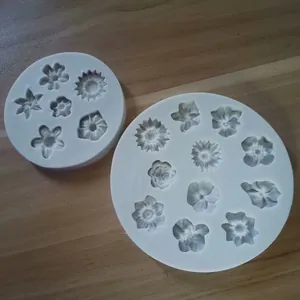 Dettaglio di due stampi in silicone rotondi bianchi con motivi floreali per decorazioni