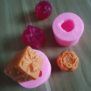 Vista detallada de moldes de silicona rosa con rosa y caja de regalo de cera o jabón