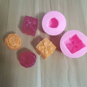 Detalle de moldes de silicona de rosa y caja de regalo con muestras de resina y jabón