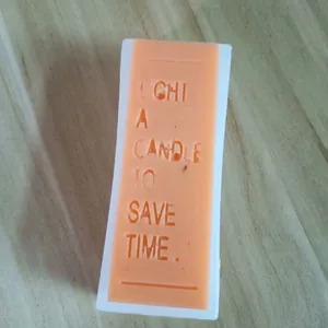Macro detail shot of a silicone mold with debossed "LIGHT A CANDLE TO SAVE TIME" message.