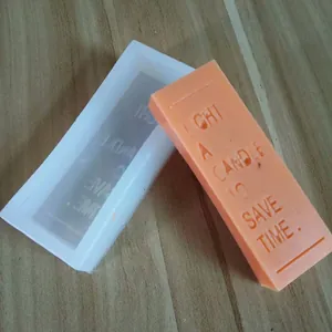 Detail of silicone mold with 'LIGHT A CANDLE TO SAVE TIME' engraving for soap and candles.