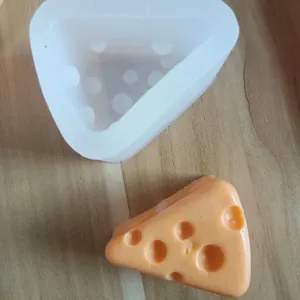 Cheese shaped silicone mold with a finished decorative piece on a wooden surface