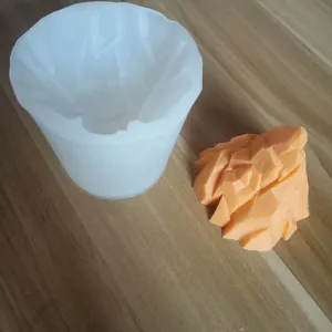 3D iceberg mountain silicone mold with finished orange mountain piece on wood table.