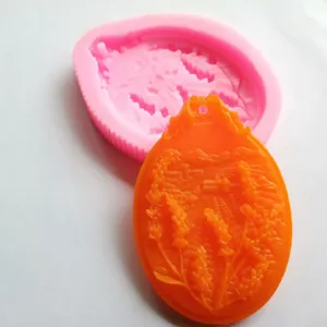 Dettaglio di uno stampo in silicone ovale e un ciondolo arancione con motivo lavanda