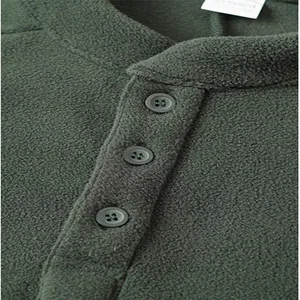 Close-up detail of green fleece sweatshirt showing button placket and texture