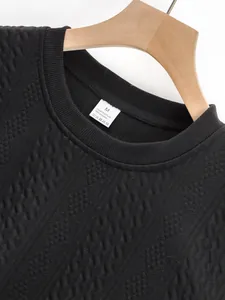 Close-up detail of black jacquard sweatshirt neckline and 100% polyester care label