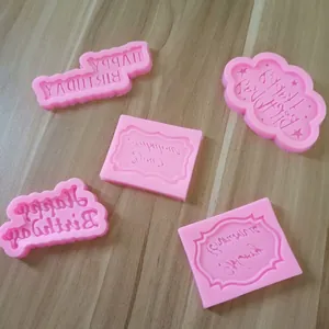 Vista dettagliata di cinque stampi in silicone rosa per decorazione torte Happy Birthday