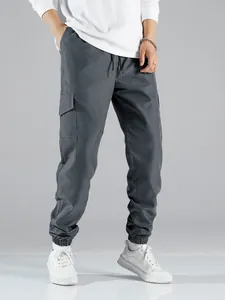 Detailed view of men's dark grey cargo jogger pants showing large side flap pockets and cuffs