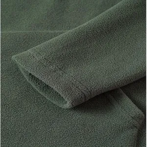 Close-up detail of the soft polar fleece fabric and sleeve cuff of a green men's sweatshirt.