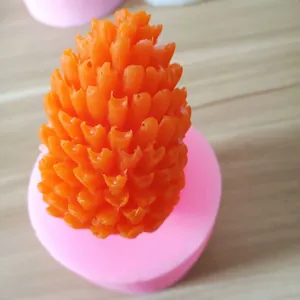 Close-up of a realistic orange pinecone candle made from the silicone mold.