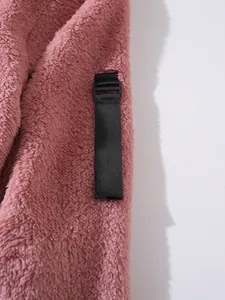 Detailansicht eines rosa Fleece-Kapuzenpullovers mit schwarzem Riemen und Schnalle