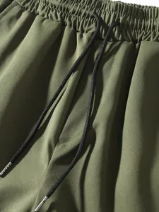 Detailed view of olive green cargo pants featuring elastic waist and black drawstring