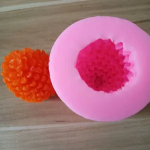 Detail view of pink silicone pine cone mold with orange finished resin model