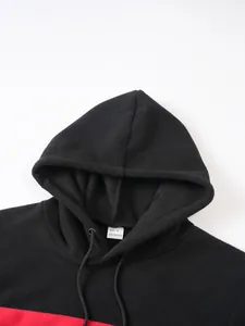 Detail view of men's black fleece hoodie with red colorblock and size S neck label