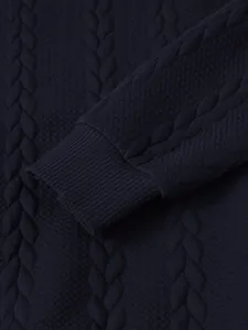 Detailed macro view of navy blue cable knit sweater showing ribbed cuff and fabric texture