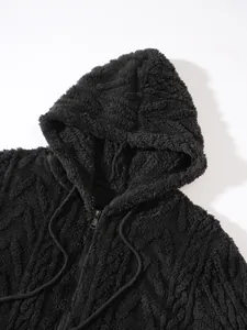 Detailopname van een zwart harig jack met capuchon en zachte sherpa-textuur en rits