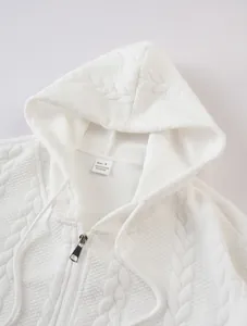 Detailed view of the textured jacquard cable knit on a white hooded zip-up sweatshirt