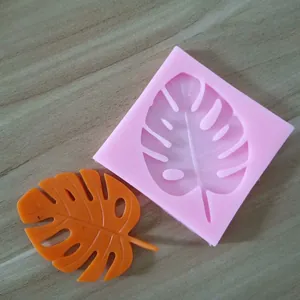 Detail showing a pink Monstera leaf silicone mold with a finished orange leaf sample.