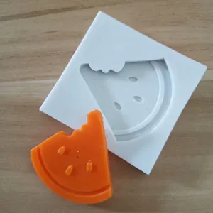 Detailed view of a white silicone mold and orange bitten watermelon slice garnish
