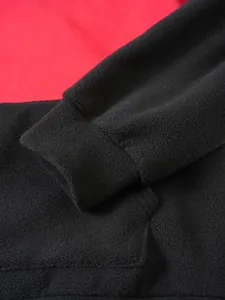 Close-up of black elastic cuff on a red and black color block fleece hoodie.