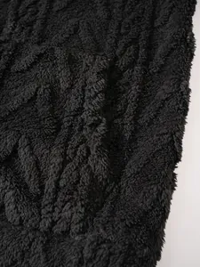 Detailopname van zwarte pluizige gestreepte textuur op een herenhoodie of huispak.