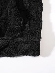 Dettaglio macro del tessuto in pile nero che mostra la consistenza spessa e l'orlo