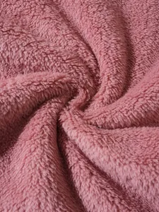 Macro detail shot showing the soft texture of pink fuzzy fleece fabric for hoodies.