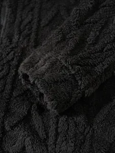 Macrodetail van zwarte pluizige fleece hoodie met dikke getextureerde ribstof