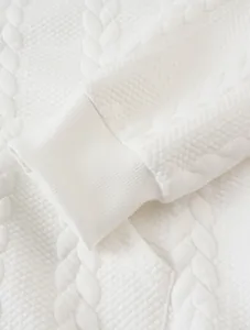Close-up detail of white jacquard fabric and ribbed cuff on a men's casual hoodie.