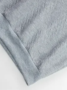Detailed macro view of grey jacquard fabric and ribbed cuff of a men's sweatshirt