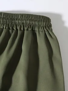 Close-up of olive green men's cargo pants featuring a durable elastic waistband detail