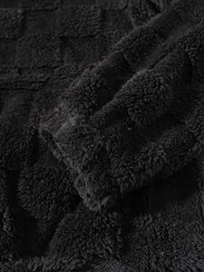 Macro dettaglio della trama a scacchi in pelliccia nera su una felpa con cappuccio casual