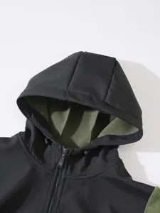 Détail rapproché d'une veste à capuche noire chaude avec doublure polaire verte et zip.