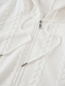 Detailed close-up of white jacquard knit texture on casual men's zip-up hooded sweatshirt