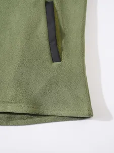 Gros plan d'un sweat à capuche en polaire vert olive montrant la poche