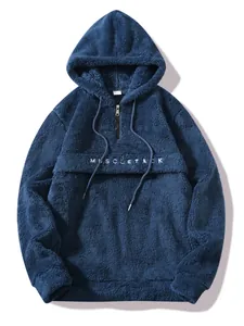 Detail view of men's blue plush fleece half-zip hoodie featuring front pocket embroidery