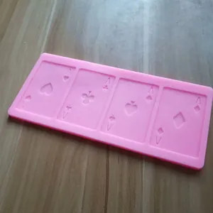 Detaillierte Makroansicht einer rosa Silikonform mit vier Ass-Spielkartendesigns