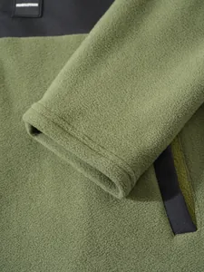 Gros plan sur la texture du tissu polaire olive et les détails de la poche noire