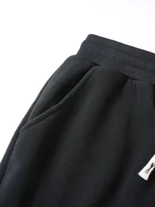 Détail macro d'une veste en polaire noire avec taille élastique et poche latérale