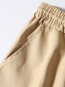 Macro detail of elastic waistband and side pocket on beige cotton cargo pants for men