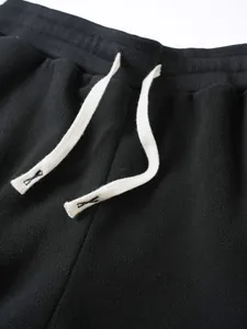Détail de l'ourlet du sweat en polaire noire avec cordon de serrage blanc réglable